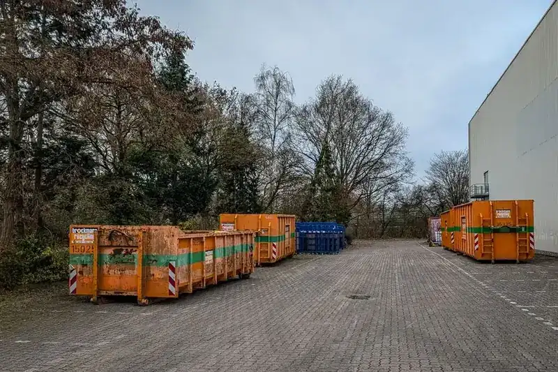 Industrial waste containers lined up at a disposal site, where wrapped asbestos waste from Carlisle homes has to be taken