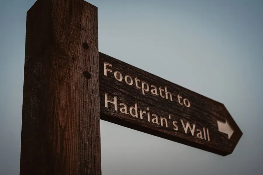 Wooden fingerpost pointing the footpath to Hadrian's Wall, the World Heritage Site that lies about two miles north of Brampton