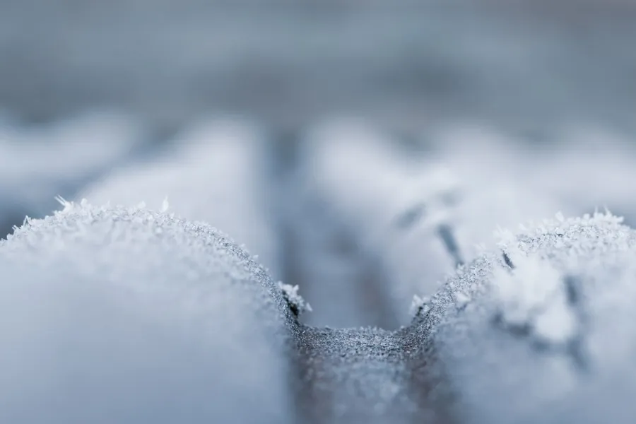 Close-up of frost forming across a cold roof surface, the moment freeze-thaw damage begins