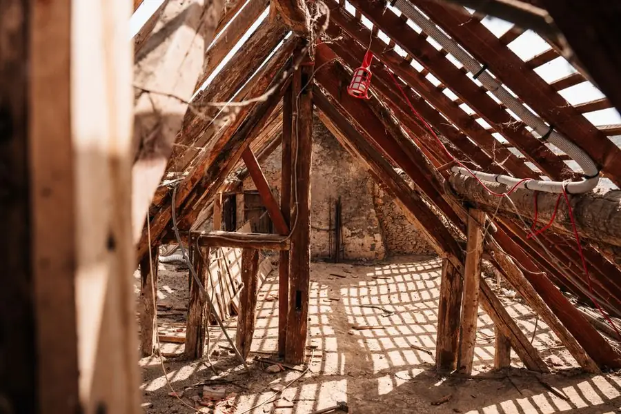Exposed roof rafters and framing in an open roof space, the structure revealed once a Carlisle roof covering is stripped