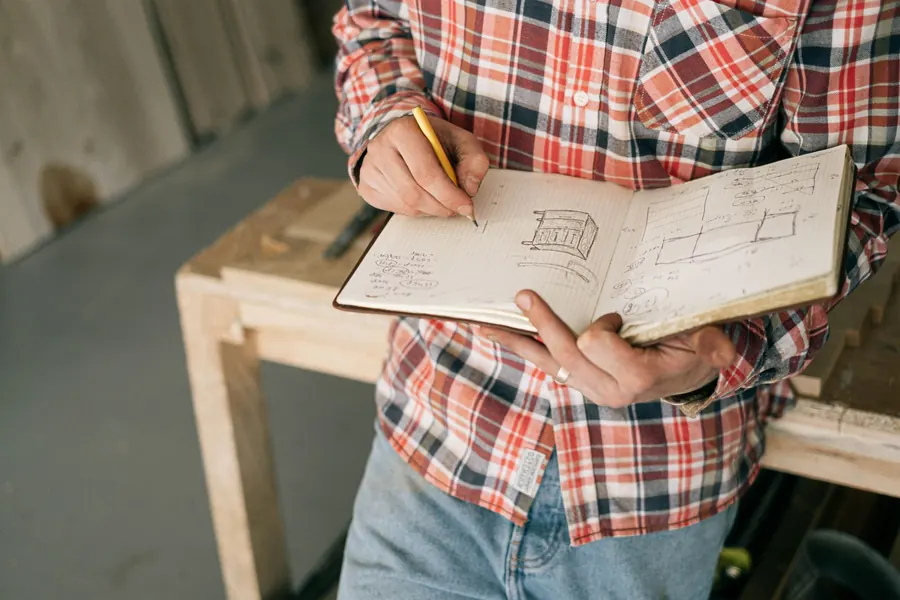 Notes and sketches being written into a notebook, the measurements a roof survey in Brampton or Wetheral turns into a written quote