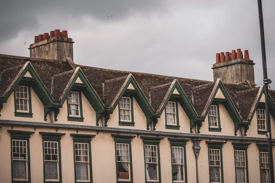 Row of Victorian gabled dormers with painted timber bargeboards and brackets, the kind of original detail found in conservation areas