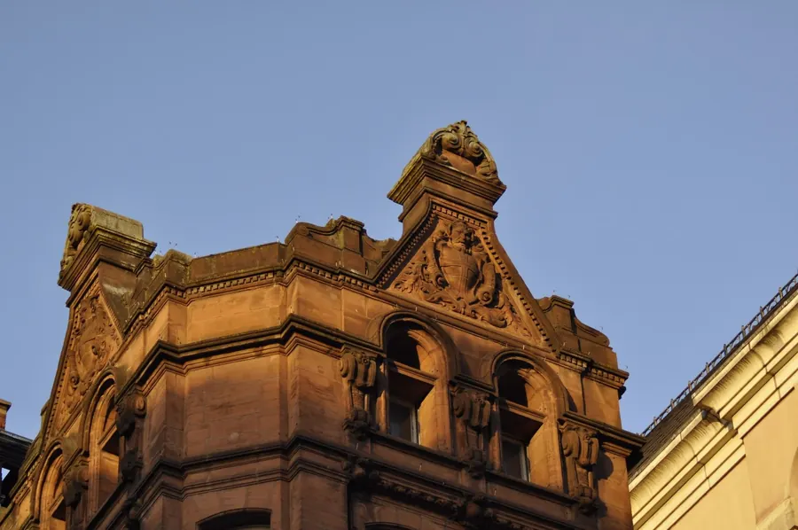 Gable and parapet detail on a red sandstone building, the roof edges where wind-driven rain gets into Carlisle properties
