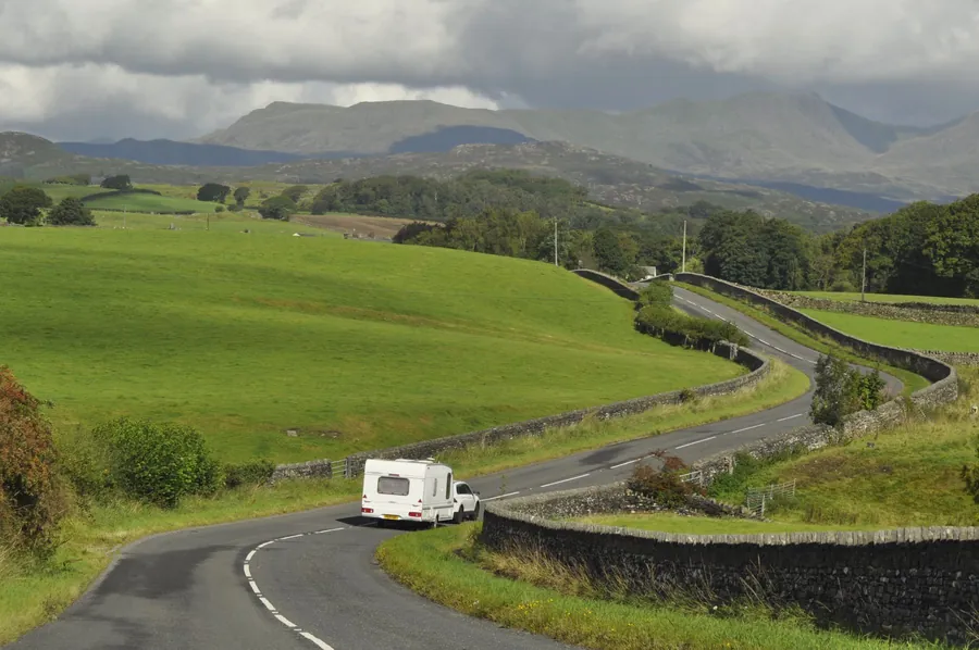 A road winding between dry stone walls towards the Cumbrian fells, the kind of run that puts Penrith half an hour from Carlisle