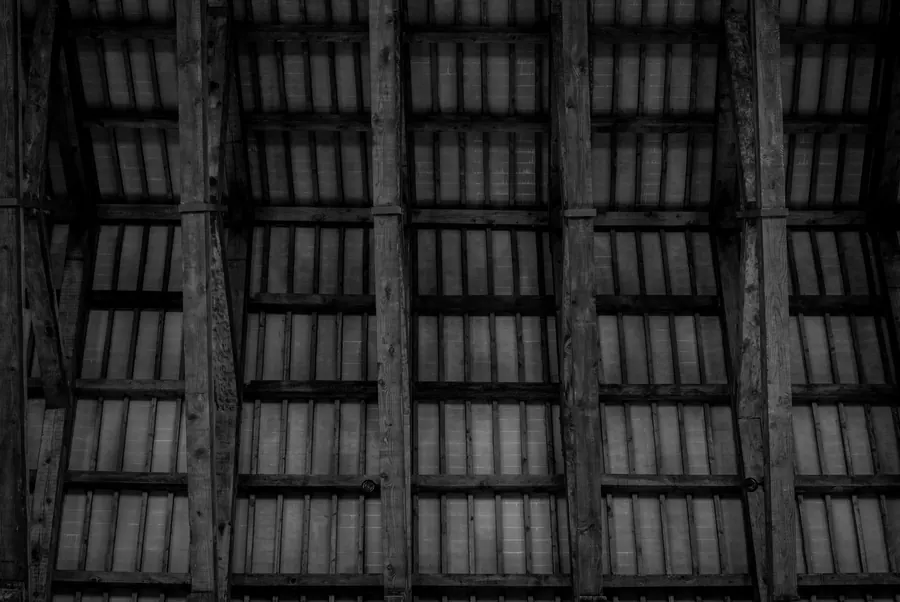 Rafters and the underside of a roof covering seen from inside the roof space, where soffit vents supply the airflow