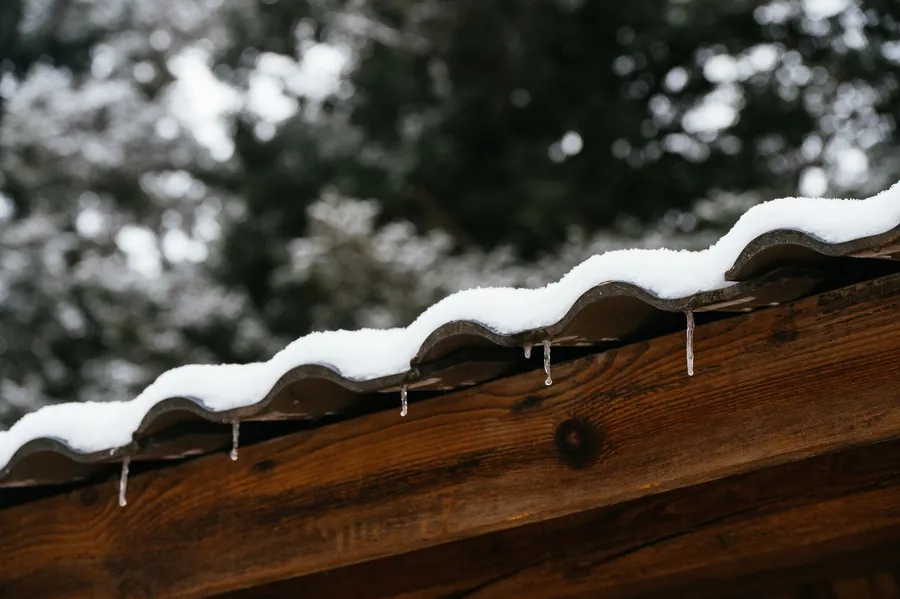 A snow-covered roof with icicles at the edge, the state a Carlisle roof reaches several times each winter