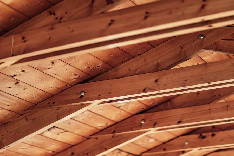 Underside of a pitched roof showing rafters and timber boarding, the surface spray foam insulation is applied to in Carlisle lofts