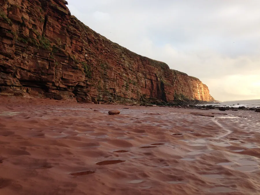 Red sandstone cliffs on the Cumbrian coast at St Bees, the same family of stone that Penrith's chimneys and terraces are built from