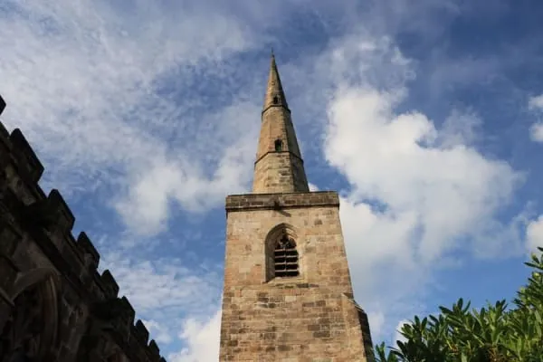 A sandstone parish church against a big sky, in the manner of Arthuret Church at Longtown