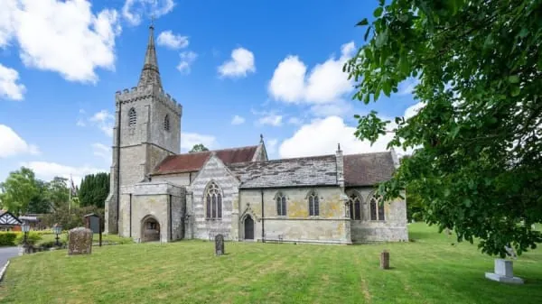 A stone village church with a squat tower, the kind of building St Michael's at Dalston represents
