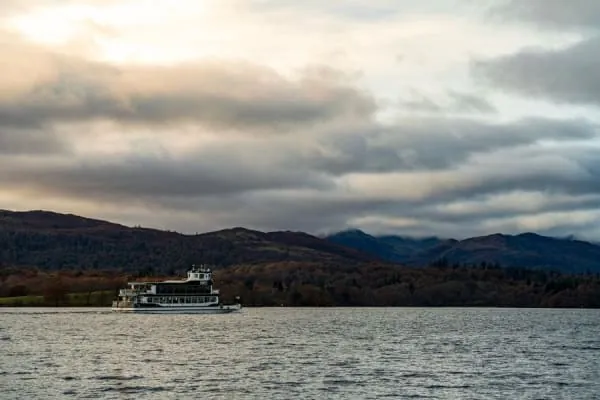 A cruise boat crossing the lake beneath autumn fells, the year-round scene on Windermere