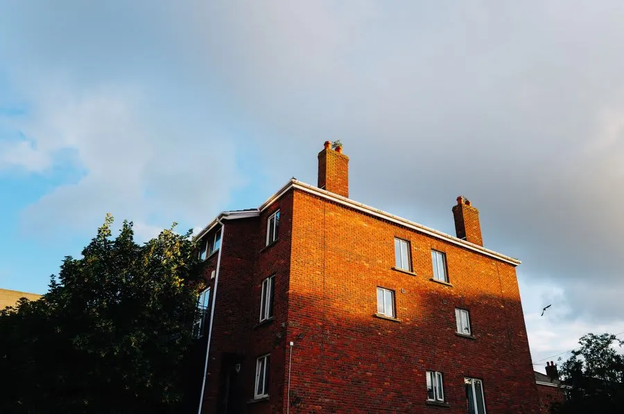 A brick house with a pitched roof and chimney stack