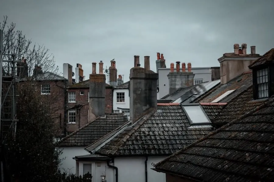 Rooftops and chimney stacks under a grey sky, the view a drone survey gives a nervous buyer