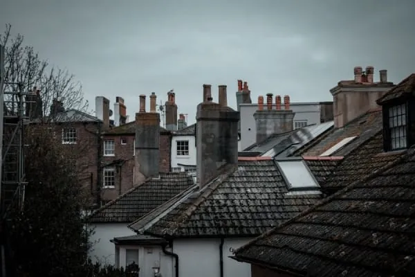 Chimney pots and flaunching on a stone stack, the crown detail on Windermere's villa roofs