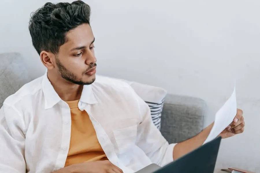 Homeowner at home reading through roofing firm reviews and paperwork before booking a quote in Carlisle