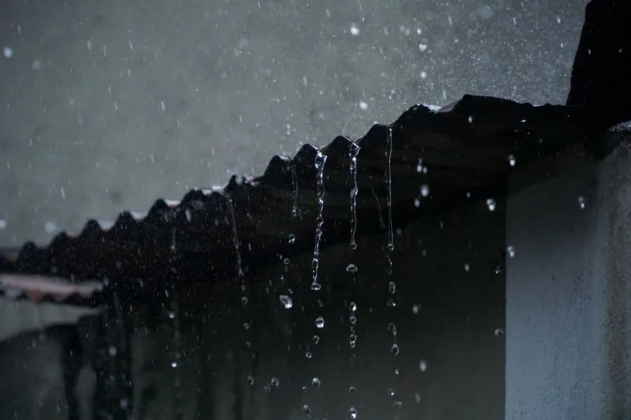 Rain dripping from the edge of a roof