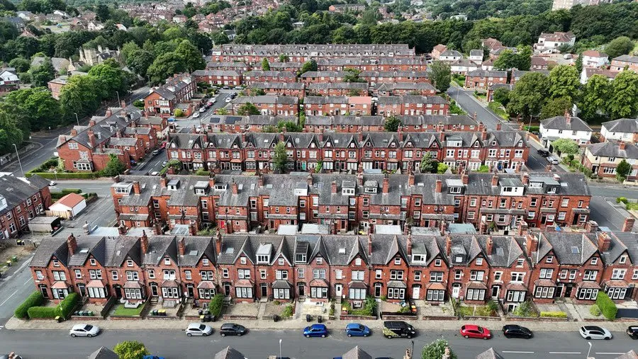 Aerial view over terraced house rooflines showing the uneven ridge lines common on older streets