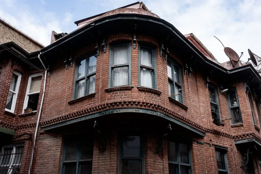Brick house roofline with gutters and eaves detail, the part of a Carlisle roof that fails quietly